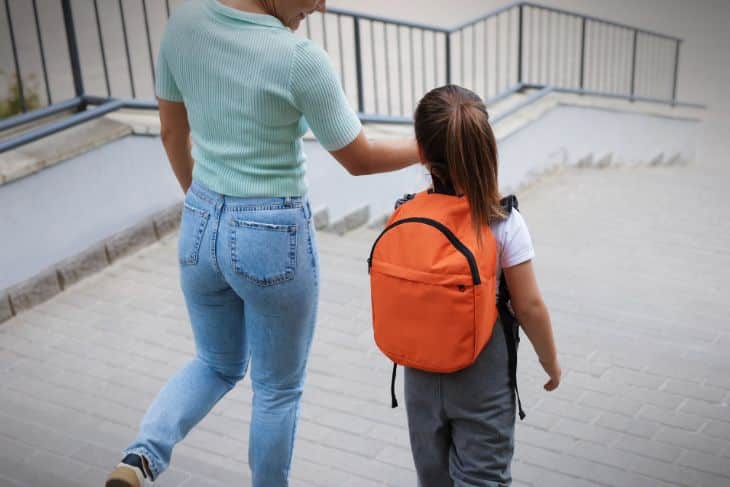 A kid carrying a school bag on their back - Chiropractic Care